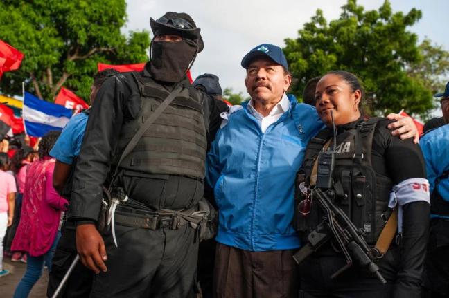 Nicaraguan police have their picture taken with President Daniel Ortega in Masaya, Nicaragua, July 13, 2018. (AP Photo/Cristobal Venegas, File)