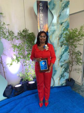 Ann Marie Brown-Burgess, fashion design lecturer at Montego Bay Community College, with her JTA Golden Torch Award for 35 years of service in the education sector.