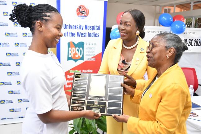 Sashara Rust (left), operating theatre nurse, Tony Thwaites Wing Operating Theatre, The University Hospital of the West Indies (UHWI); accepts her Nurse of Excellence award from Helena Thomson (right), senior director of nursing at the UHWI; and Delories J