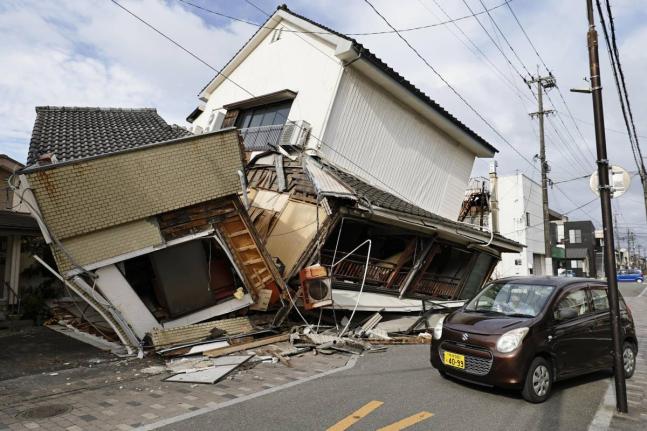 A vehicle passes by collapsed houses after an earthquake in Yatsushiro, Kumamoto prefecture in southwestern Japan on Wednesday. – AP photo