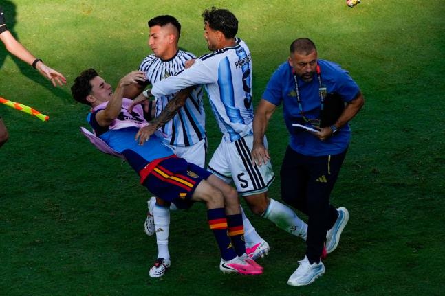 Spain's Gavi, left, falls as he scuffles with Argentina's Leandro Paredes (5) and Thiago Almada during the World Cup final soccer match between Spain and Argentina in East Rutherford, N.J., near New York, Sunday, July 19, 2026. (AP Photo/Yuki Iwamura)