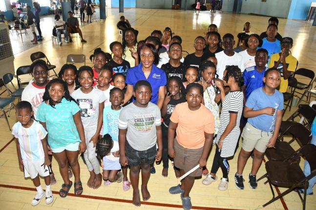 Campers at the YMCA Summer Camp pose for a group photo with Rose Miller, financial education consultant at the JN Foundation, following an interactive financial literacy session on budgeting, saving and investing.