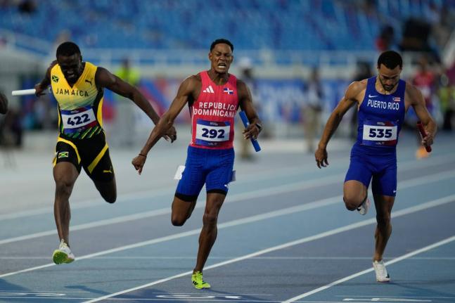 Dominican Republic’s Yancarlos Martinez (centre)  crosses the finish line to win the gold medal in the men’s 4x100-meter relay final at the Central American and Caribbean Games in Santo Domingo, Dominican Republic  yesterday. Jamaica (left) were second