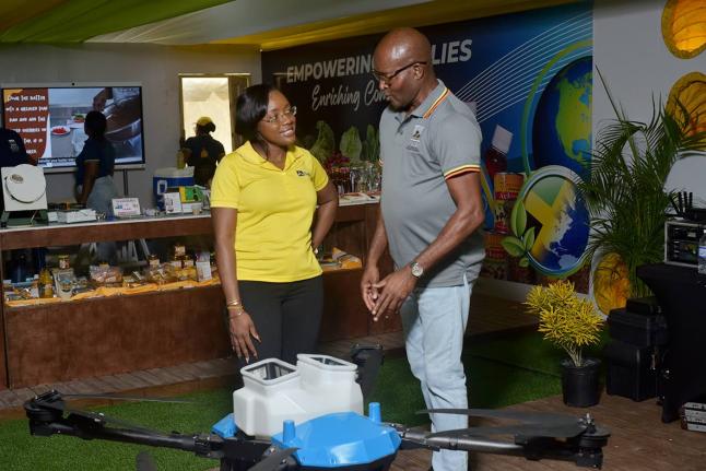 Alecia Clarke, business solutions manager at JN Bank, listens with interest as Rural Agricultural Development Authority (RADA) Chief Executive Officer Garnet Edmondson outlines the capabilities of the Samson One drone, developed by Jamaican technology comp