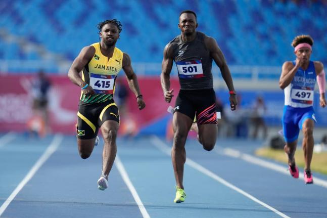 AP 
Jamaica’s Bouwahjgie Nkrumie (left) and Panama’s Arturo Deliser compete in a men’s 100-metre heat at the Central American and Caribbean Games in Santo Domingo, Dominican Republic, Monday, August 3.
