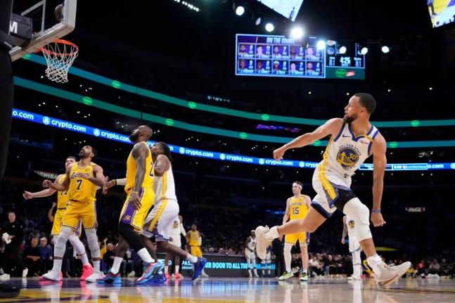 FILE - Golden State Warriors guard Stephen Curry, right, watches his shot go in during the first half of an NBA basketball game against the Los Angeles Lakers in Los Angeles., April 3, 2025. (AP Photo/Mark J. Terrill, File)