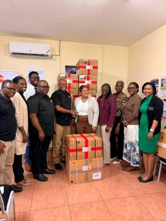 Harold Robinson (centre), director and representative, United Nations Population Fund (UNFPA) Sub-Regional Office for the Caribbean, formally hands over UNFPA’s donation of reproductive health and midwifery kits to Kristal Lee, Minister of State in the M