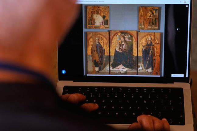 A journalist browses the Messina museum website showing a picture of the Early Renaissance painter Antonello da Messina’s artwork where three of the five panels belonging to the Polyptych of San Gregorio and the double-sided panel with the Madonna and th