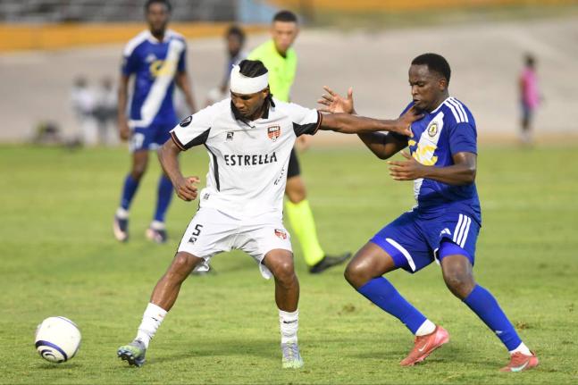 Cebao FC’s Luis Diaz (left), keeps Mount Pleasant Football Academy’s Trayvone Reid during their Caribbean Cup encounter at the National Stadium yesterday. 
