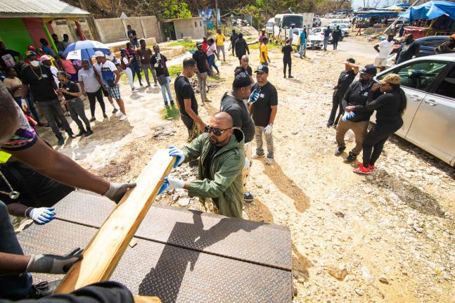 Recording artiste and philanthropist Sean Paul offloads lumber at Scott’s Cove, more popularly known as Border fishing village, between St Elizabeth and Westmoreland, on November 13.