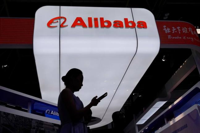 A visitor walks in front of Alibaba’s booth during the 3rd China International Supply Chain Expo at the China International Exhibition Center in Beijing, China, in July 2025.  AP