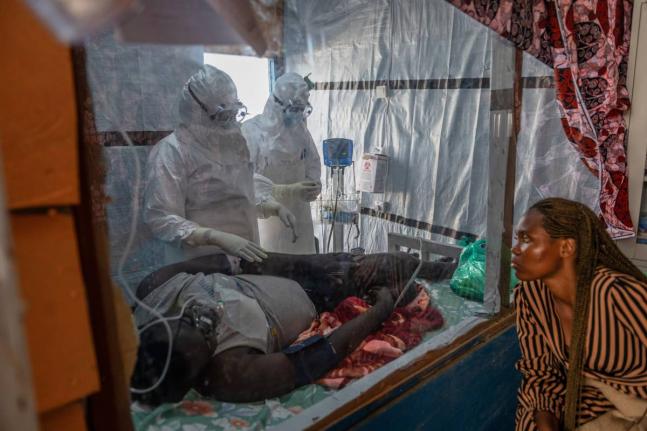 Health workers tend to an Ebola patient at the Rwampara Treatment Center in Ituri, Congo.