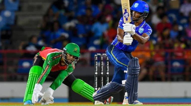 Guyana Amazon Warriors wicketkeeper Shai Hope (left) watches as Ackeem Auguste goes on the attack during a Caribbean Premier League game.