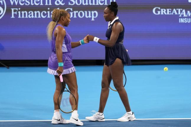 Serena Williams (left) first bumps Venus Williams (right), both of the United States, during a women's doubles match against Marta Kostyuk of Ukraine, and Peyton Stearns of the United States, at the Cincinnati Open tennis tournament on Monday, August 17, i