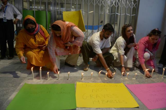 People light candles in the memory of the newborn victims outside the Mother and Child Health ward at the Pakistan Institute of Medical Sciences, in Islamabad, Pakistan.