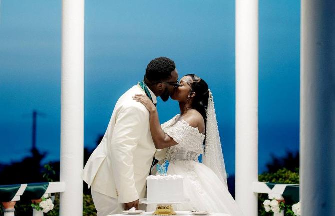 The groom leans in to give his bride a sweet kiss.