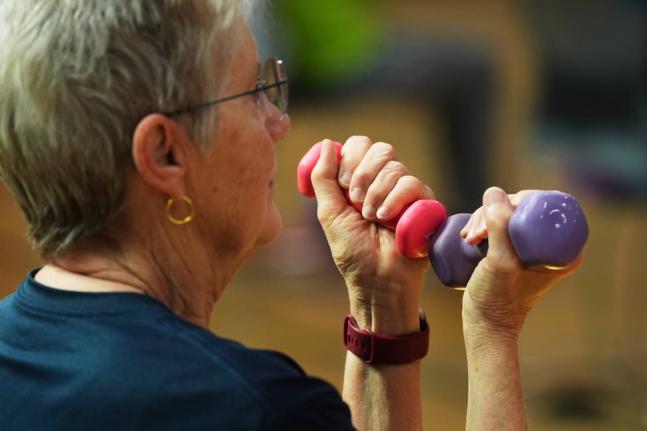 A participant uses light weights during a class for older adults at the Dale Turner Family YMCA in Shoreline, Washington, on April 30.