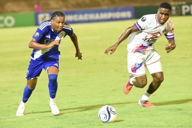 Mount Pleasant Football Academy's Nickalia Fuller (left) and Portmore United's Akeem Mullings compete for the ball during their Concacaf Caribbean Cup football match at the National Stadium yesterday.