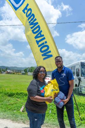 Omar Wright (right), lead, Environment and Community Development at the JN Foundation, presents a care package to Norma Fenton, president of the Petersfield Galloway Benevolent Society during a medical mission to the community, recently. The JN Foundation 