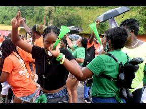 Two Jamaica Labour Party supporters blow their vuvuzela in West Rural St Andrew while their People's National Party counterparts celebrate at the Mannings Hill Primary School.