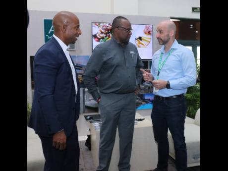 Director of Tourism Donovan White (centre) converses with the president of the Jamaica Hotel and Tourist Association, Omar Robinson (left), and Koen Heitbrink, general manager, AC Hotel Kingston, at the JAPEX Trade Show at the Montego Bay Convention Centre.