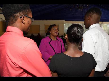 Rosalee Gage-Grey (second left), CEO of the Child Protection and Family Services Agency, gives a word of encouragement to wards of the State who did well in their CSEC and CAPE examinations for 2019. They were attending the CPFSA 2019 Educational Achievement Awards Ceremony at the Terra Nova Hotel on Thursday.  