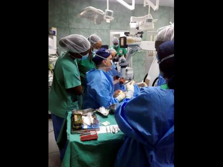 Team members of the Maimonides Medical Center in New York and The University of the West Indies conduct a procedure on an unidentified patient during an American Friends of Jamaica operation last week.
