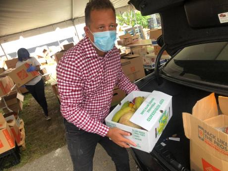 Credit: Contributed
Consular General Oliver Mair preparing care packages in South Florida. Members of the Caribbean diaspora are among those hit with unemployment and salary cuts in the United States, with many finding it harder to send remittances to their families back home.