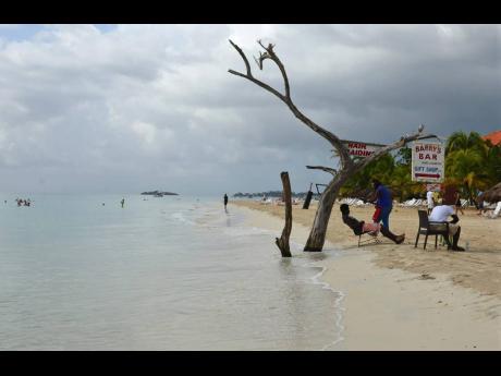 In this 2014 photo, the tide gnaws away at a badly eroding patch of resort-lined beach in Negril in western Jamaica.