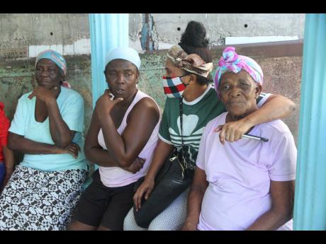Seventy-nine-year-old Perris Samuels (right) is comforted by a family friend as she shares memories of her son Evriel Mitchell with his sisters Doreen Samuels and Pauline Anderson.
