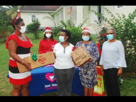 Janet Richards (left) hands a box of goodies to Yvette Mahoney, operations manager at Montego Bay Community Home for Girls (Melody House) in Irwin, Montego Bay.