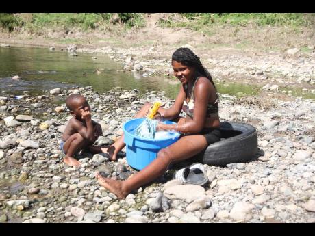 Crystal Christian is accompanied by her two children and nieces as she does her washing in the Rio Minho. 
