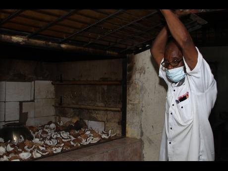 Lincoln Gordon lifts the lid to reveal an assortment of dried coconuts to be used in the manufacturing process at his Clarendon-bases business.