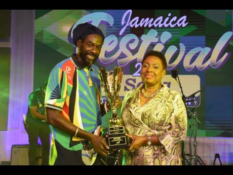 Buju Banton (left), the winner of the 2020 Jamaica Festival Song Competition, receives his winning trophy from  Minister of Culture, Gender, Entertainment and Sport Olivia Grange at the competition’s televised grand final last July.
