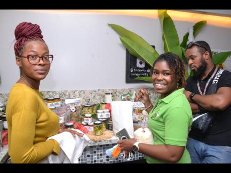 From left: Romyah Jackson  from Stush in the Bush gives Tatianna Thomas-Hill  and Claudious Grapine a brief history of the natural products on display. 
