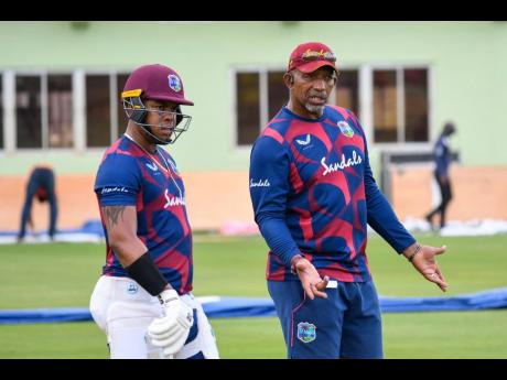 West Indies’ coach Phil Simmons gives a few pointers to batsman Shimron Hetmyer during a practice session in Guyana, yesterday.