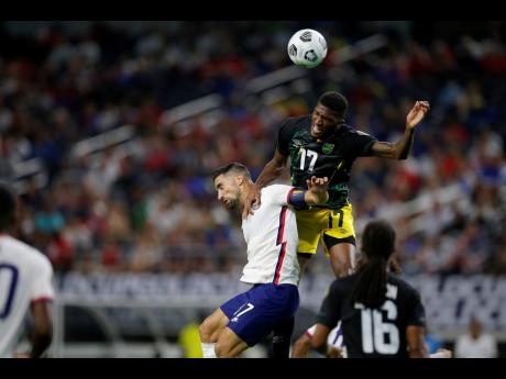 Credit: File Jamaica defender Damion Lowe (top) leaps to head the ball over United States midfielder Sebastian Lletget as midfielder Daniel Johnson (16) looks on in the second half of a Concacaf Gold Cup quarter-final match in Arlington, Texas, on Sunday, July 25.