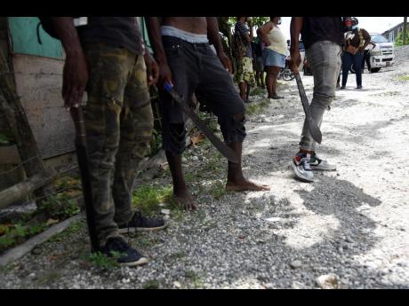 Residents from the Bath and Arcadia in St Thomas on standby with machetes in the hunt for abduction suspect Davian Bryan.