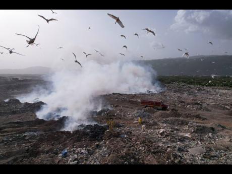 Credit: Ricardo Makyn Plumes of smoke billowing from the Riverton City dump in St Andrew last month as a fire rages at the eastern side of the disposal site.