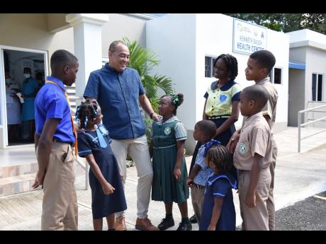 Dr Christopher Tufton (centre), minister of health and wellness, interacts with students during a tour of the refurbished Dr Kenneth Baugh Health Centre in Point Hill, St Catherine, during an Adopt-a-Clinic ceremony on Wednesday. 