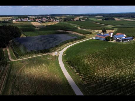 Credit: AP Solar panels are mounted on poles above a hops field near Au in der Hallertau, Germany, Wednesday, July 19, 2023. Solar panels atop crops has been gaining traction in recent years as incentives and demand for clean energy skyrocket.