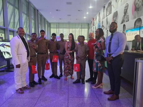 B. B. Coke High School’s heroic students, Leon Barnes (second left), Khari Green (third left), Gary Bartley (fourth left), Daejuan Gordon (fifth left) and Dejaun Powell (fourth right) collect their tokens at Digicel headquarters in downtown Kingston rec