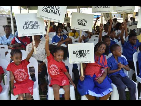 Credit: Nicholas Nunes/Photographer Youngsters holding signs bearing the names of children who died tragically between October 2022 and October 2023.