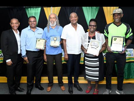 Credit: Rudolph Brown The Jamaica Football Federation (JFF) honoured four stalwarts who contributed significantly to local football development at the JFF head office in New Kingston yesterday. Dennis Chung (left), JFF general secretary and Michael Ricketts, (third right) pre