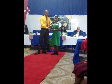 Top girl Chrisanique Mighty is presented with her trophy by Justice of the Peace Lynworth Brown, while Superintendent of Police Derrick Champagnie and principal Beverly Cytall look on