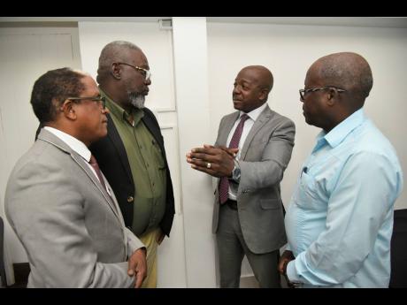 Pearnel Charles Jr (second left), minister of labour and social security, discusses fixed-term contracts with Norman Dunn (left), state minister in the labour ministry; Rudolph Thomas (second left), vice president, Bustamante Industrial Trade Union and vic