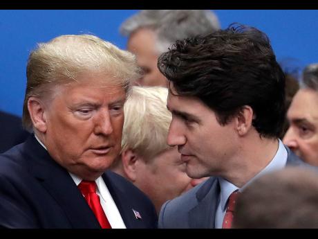 In this Wednesday, December 4, 2019, file photo, US President Donald Trump (left) and Canadian Prime Minister Justin Trudeau arrive for a round table meeting during a NATO leaders meeting at The Grove hotel and resort in Watford, Hertfordshire, England. Tr