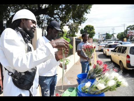 Credit: Ian Allen Shamar Green (left), Ricardo Rowe (centre) and Santana Spencer (right) prepare and sell roses along Waterloo Road in St Andrew on Valentine’s Day. See more from Valentine’s Day on Page A2.