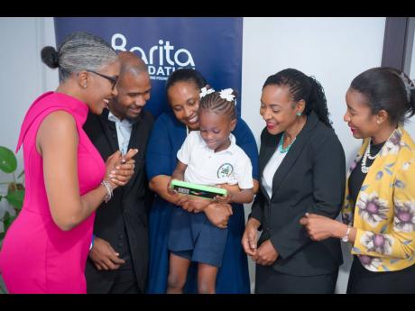 Adrianna McKnight (foreground) shows (from left) Sancia Thompson, director, Barita Foundation; Dane Brodber, interim CEO, Barita Investments Limited; Tanketa Chance-Wilson, executive director, Barita Foundation; Marsha Smith, state minister, Ministry of Ed