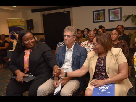 Permanent Secretary in the Ministry of Justice, Grace-Ann Stewart McFarlane (right), greets United Nations Development Programme Programmes Specialist, Stacey-Ann Tomlinson-Knox, during a Social Justice project event at The Jamaica Pegasus hotel in New Kin